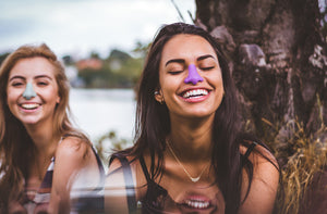 Two happy women wearing colorful sunscreen